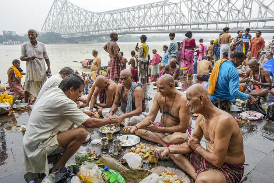 Devotees perform 'tarpan' rituals for their ancestors at the bank of River Ganga on the last day of the Pitru Paksha, in Calcutta on Oct. 2, 2024.