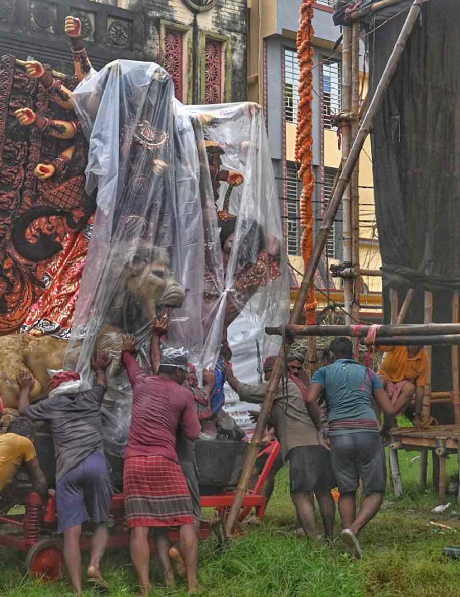 Workers carry a Durga idol to a pandal in Baruipur on the city’s southern fringes amid rain on Mahalaya morning on Wednesday