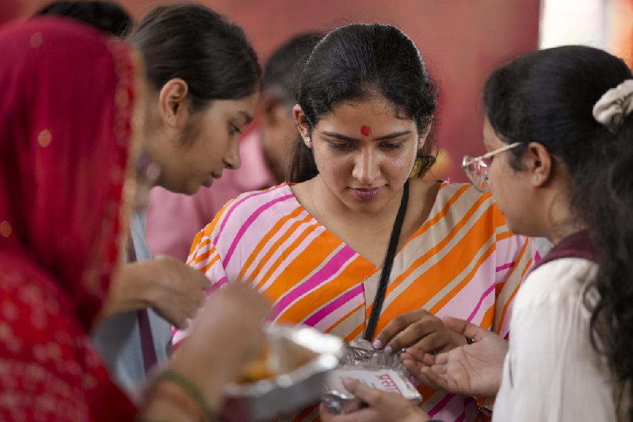 SACRED OFFERINGS: Devotees in New Delhi receive 'Prasadam' at the Jhandewala Devi Mandir Thursday, Oct. 3, 2024