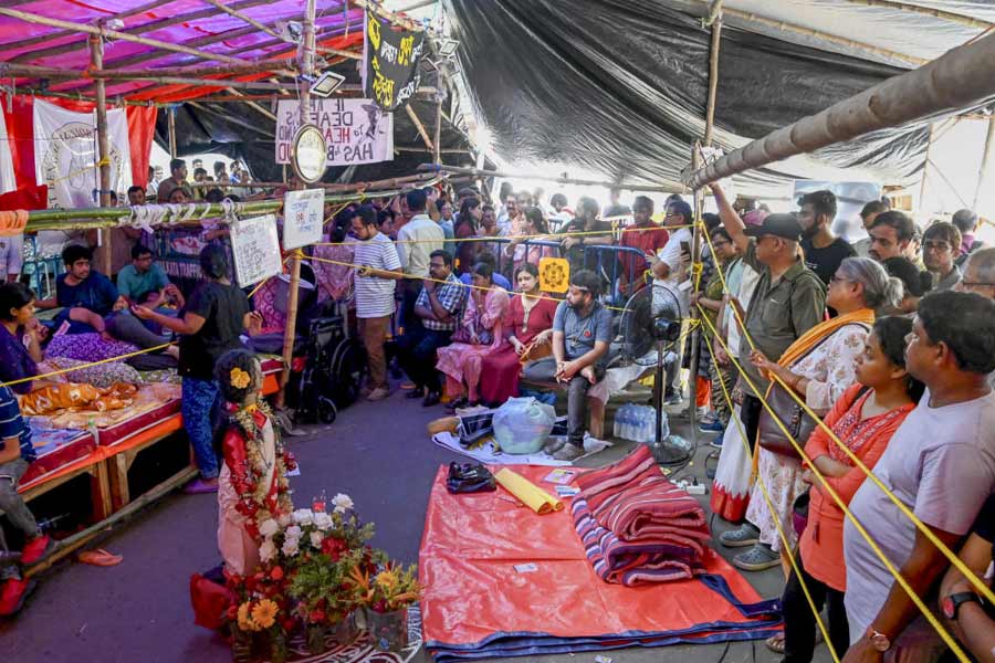 People stand near the site of junior doctors' protest against the RG Kar Medical College and Hospital rape and murder incident, in Calcutta, Monday, Oct.7, 2024.