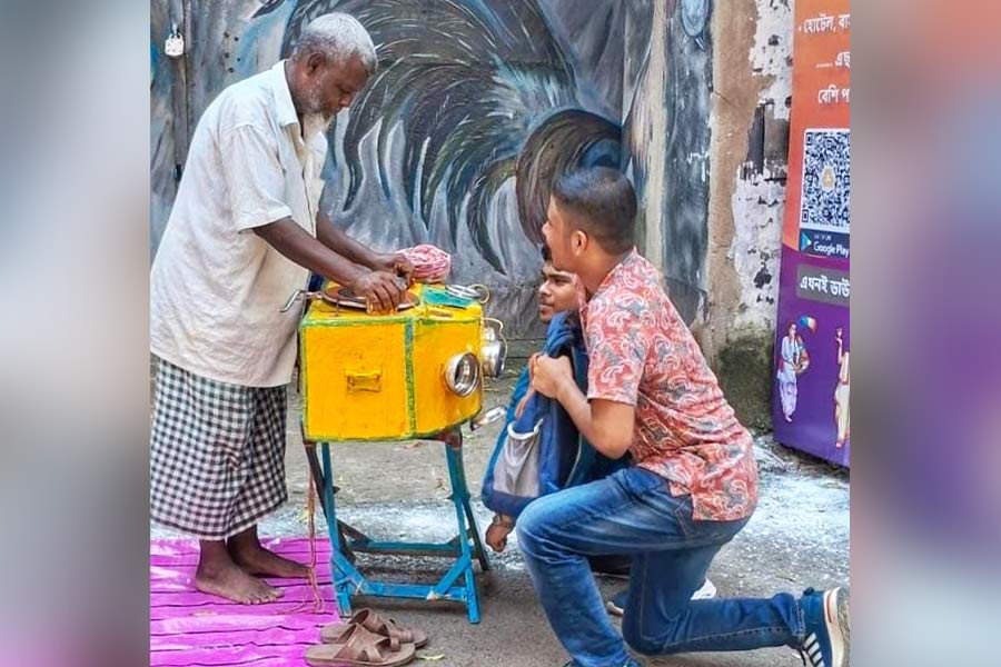 Children watch short clips in an old-fashioned bioscope. This man from Ekbalpore travels around puja pandals with this olden contraption 