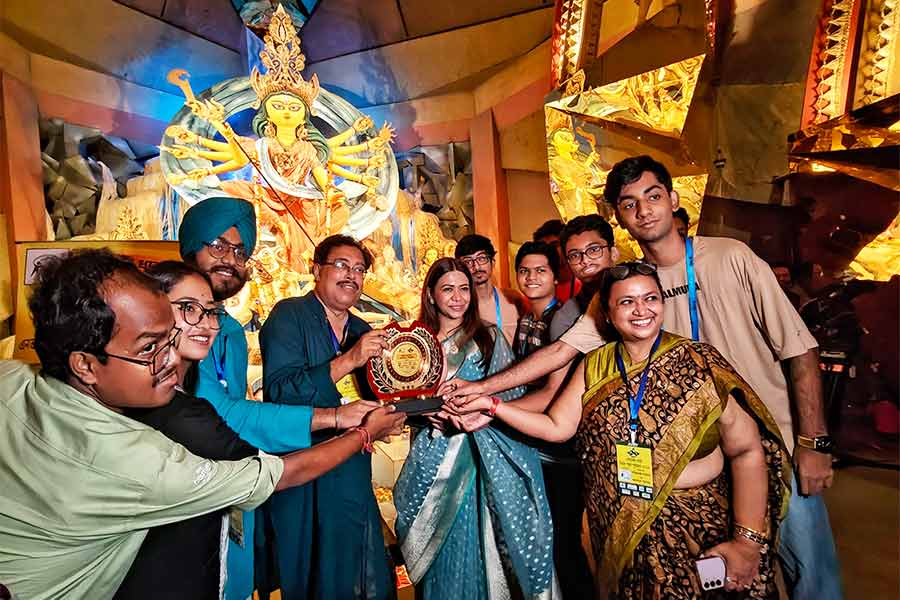 Priyadarshini Hakim (centre, in blue sari) accepted a special theme award on behalf of Chetla Agrani from the Serader Sera Nirmal Puja Puroskar team
