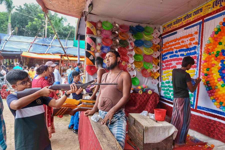 At a local fair, a young boy tried his hand at rifle shooting, aiming to win a prize by bursting balloons  