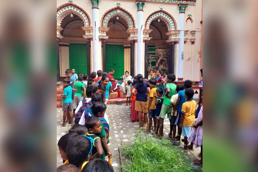 Family members distribute gifts among children in the village a week before Durga Puja