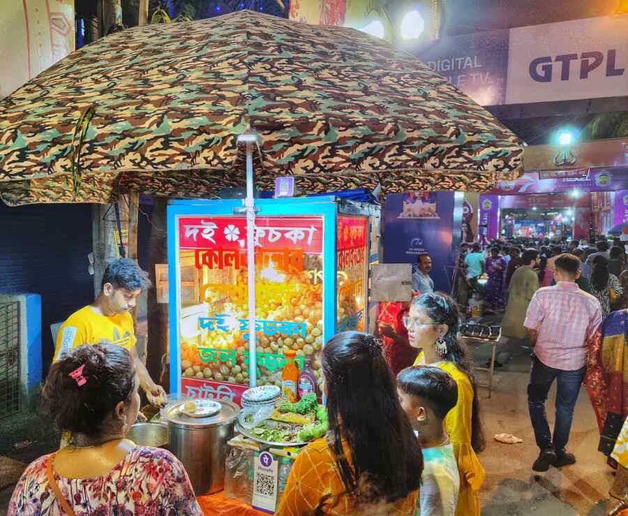 Enjoying a quick break, pandal hoppers relish Kolkata’s iconic phuchka at a stall in Dum Dum Park  
