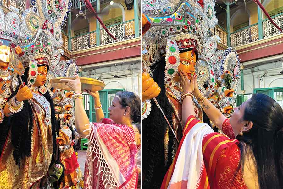 The 12-foot idol is gently carried down from the ‘dalan’ to the courtyard, where the married women of the family, dressed in ‘laal-paar shada saris’, move in a circle around the idol to begin the boron ceremony. Maa Durga, along with her children, even the lion and Asur, are given bits of ‘naarus’ to send them off on a sweet note. Though sadness fills the air as the family prepares to wait another year for Maa’s return, the rituals are deeply symbolic. Betel leaves are placed in all ten hands of the Goddess and her cheeks are lovingly touched, while the family affectionately prays and requests her to return soon