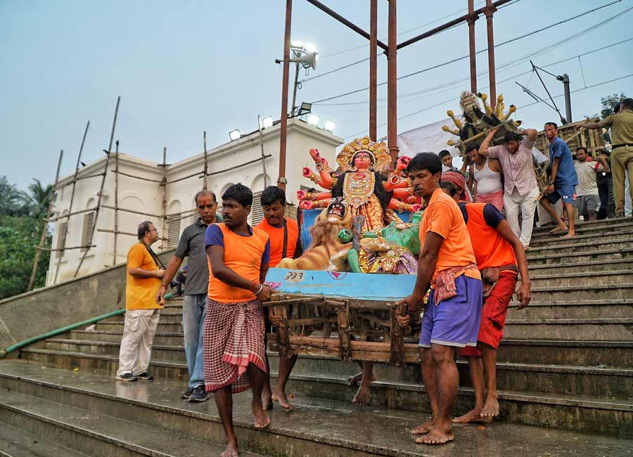 Workers carry a Durga idol for immersion at Outram Ghat on the Hooghly on Sunday evening. After festivities which lasted for more than a week starting from Mahalaya this year, it was finally time to bid a teary farewell to Durga and her children for their trip back to Mount Kailash