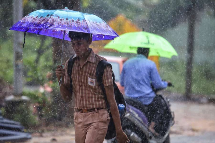 People holding umbrellas commute amid rains.