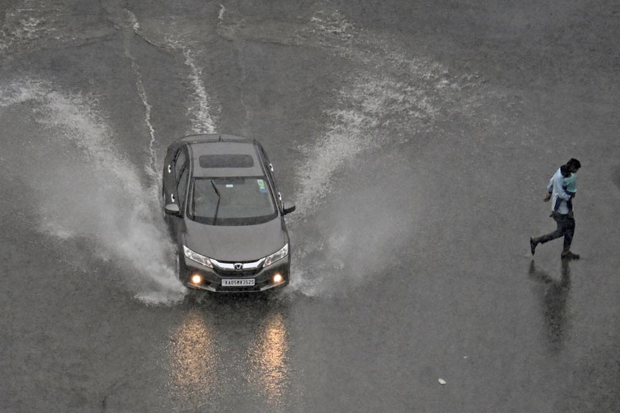 A car moves through a waterlogged road amid heavy rains in Bengaluru.