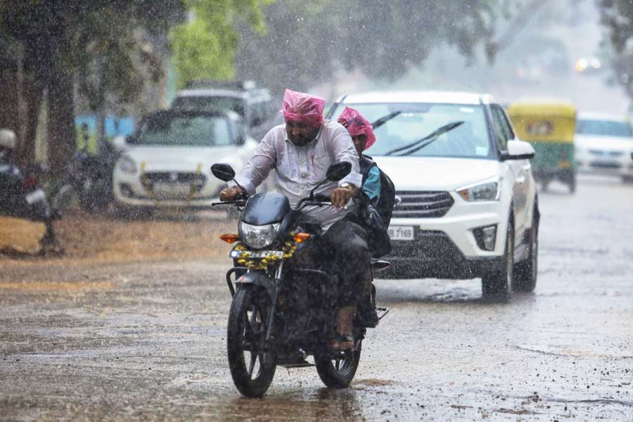 People commute amid rains due to ‘Spawn’ cyclone in Bengaluru.