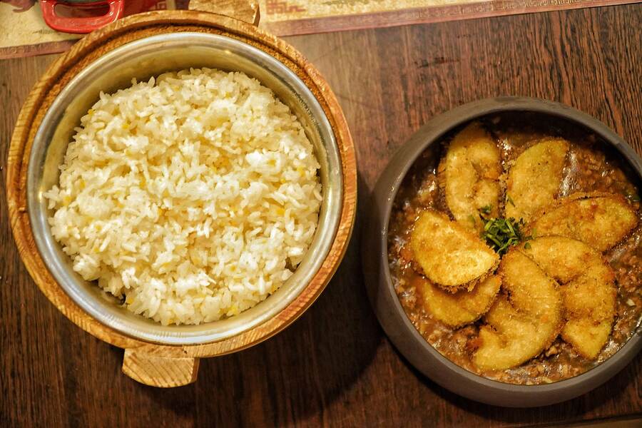 The Aubergine with Sauce has crispy, crumbed and fried slices of aubergine served in a minced chicken sauce. Best paired with steamed white rice