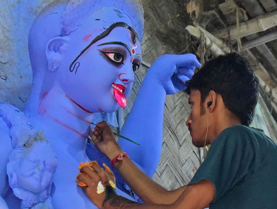 With barely 12 days to go for Kali Puja, this artisan is a picture of concentration at a studio in Kumartuli, with earphone in place