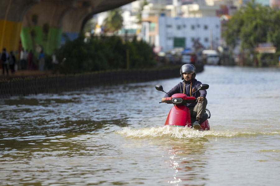  A scooterist wades through a waterlogged road after heavy rain, near Kendriya Vihar apartment in Bengaluru.