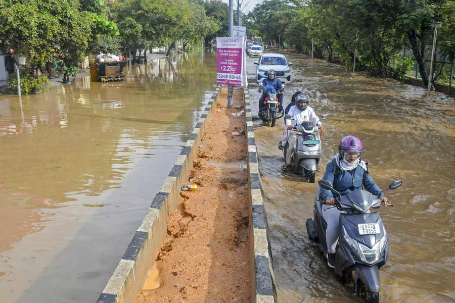 Vehicles move on a waterlogged road after heavy rain, in Bengaluru.