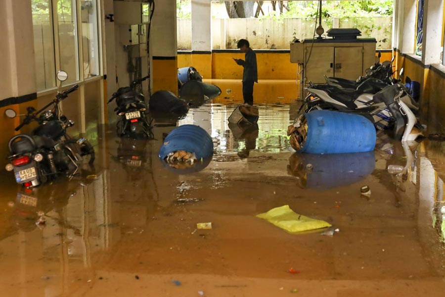 Partially submerged vehicles after water entered the parking of an apartment complex after rains in Bengaluru.