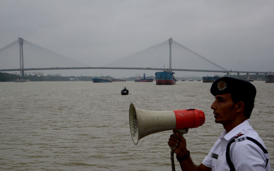 Kolkata River Traffic Guard officials warn people over public address system at Kolkata ghats ahead of Dana on Thursday