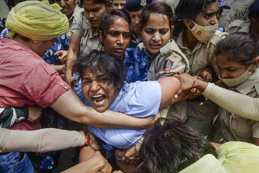 Security personnel detain wrestler Sakshi Malik during wrestlers' protest march towards new Parliament building, in New Delhi, Sunday, May 28, 2023.