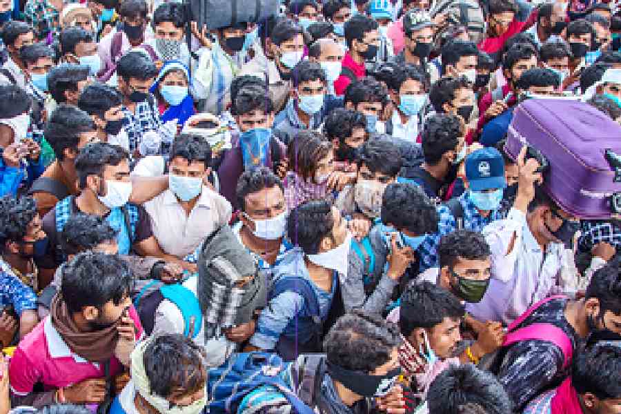 File picture of migrant workers and their families trying to board buses in Delhi to return to their villages during the nationwide lockdown in 2020.