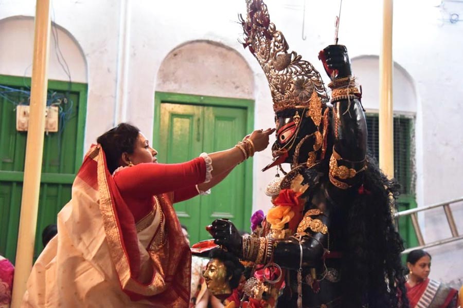 A woman performs ‘baron’ rituals on Dashami at the residence of Pramanicks