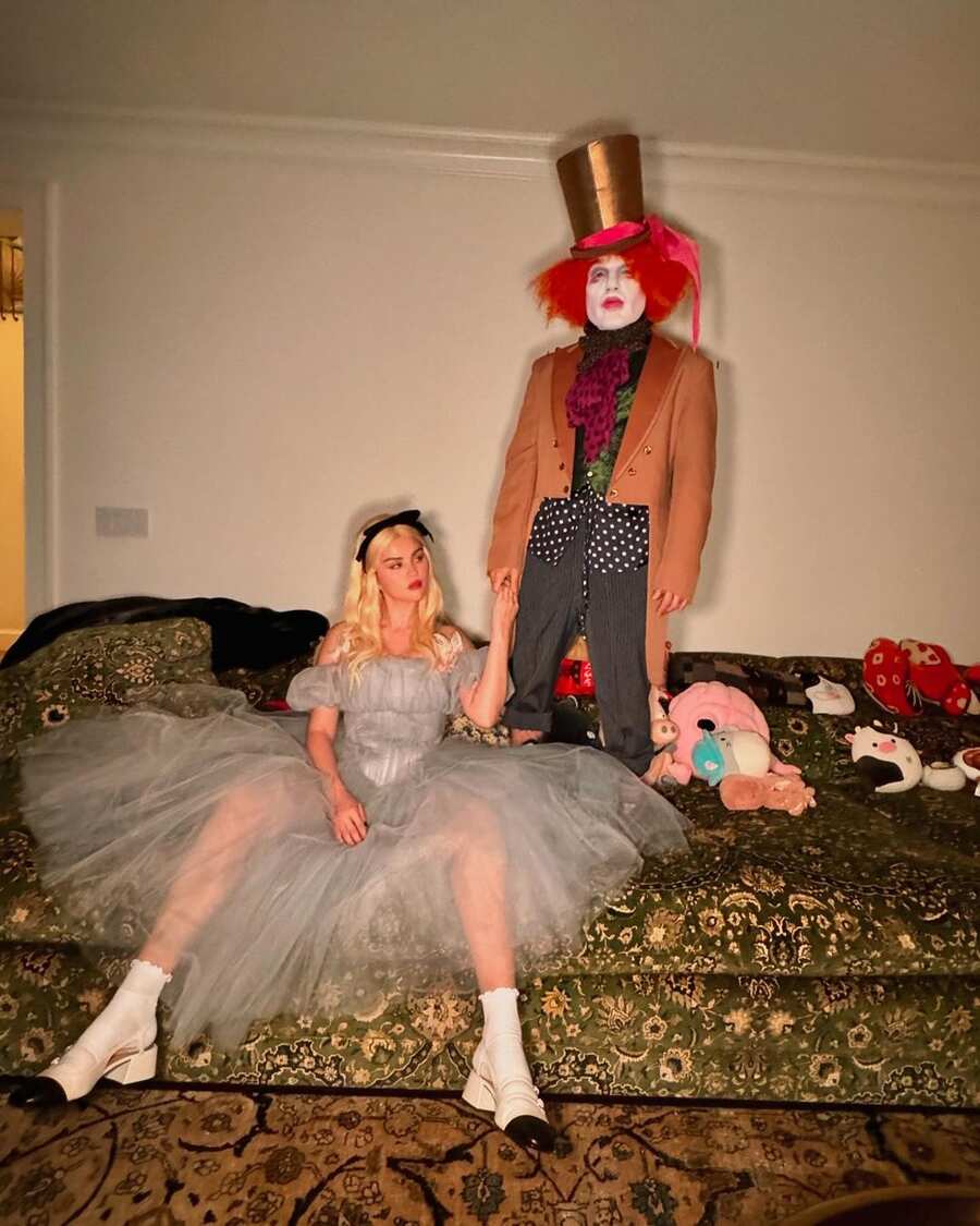 Selena Gomez and Benny Blanco took on a Tim-Burton turn with their Alice in Wonderland-look this Halloween. Selena, dressed as Alice, gave off gothic vibes in a gauzy blue-grey dress. Her blonde wig, styled in soft tresses with a black headband, complemented her smokey eyes and added a touch of whimsy. Benny, on the other hand, fully embraced the red frizzy-haired, oversized top hat-wearing eccentricity of Johnny Depp’s Mad Hatter. 