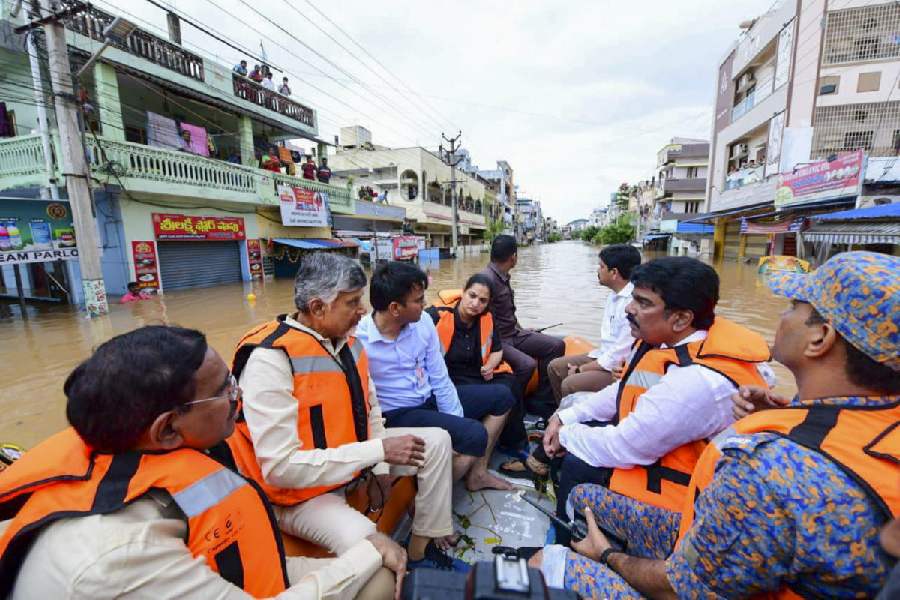 Andhra Pradesh Chief Minister N Chandrababu Naidu with others during a visit to a flood-affected area, in Vijayawada.