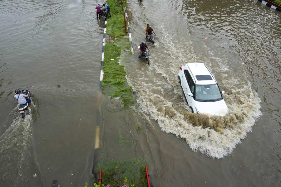  A vehicle moves through a flooded road after heavy downpour, in flash flood hit New Delhi