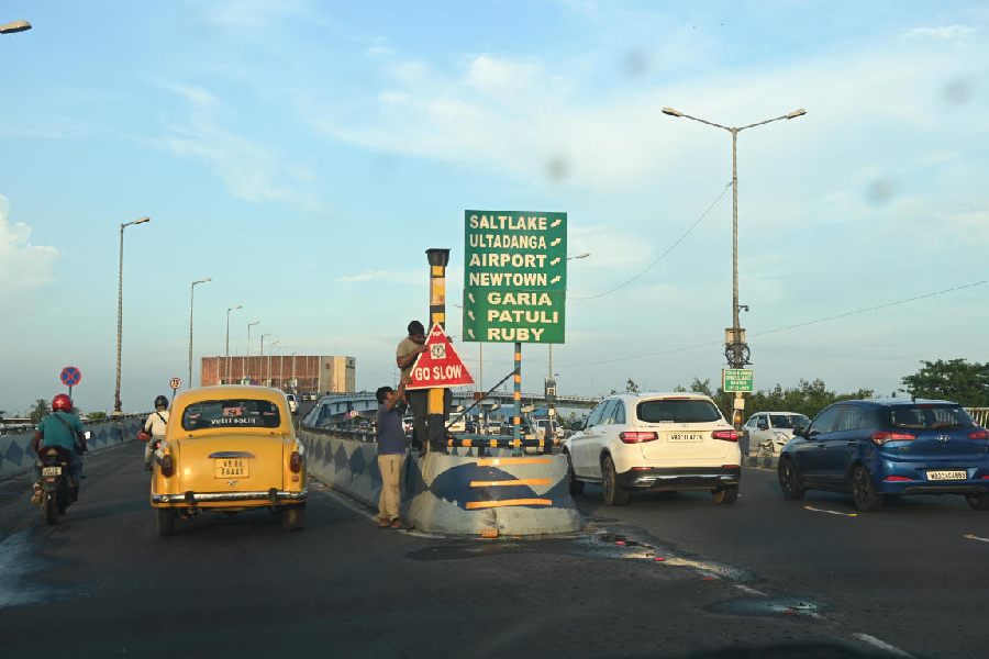 A "Go Slow" board being installed at the accident spot; reflector tapes pasted on the guard wall of the Parama flyover