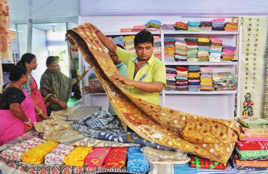 A seller arranges his wares at a pre-Puja textile exhibition fair that started from Friday at Baruipur Raas ground in South 24-Parganas. The fair will continue till September 15