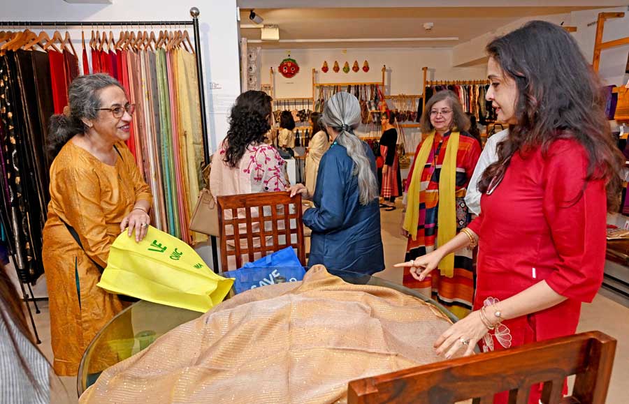 The director of CIMA, Rakhi Sarkar, looks on as guests of the Art in Life preview pick their favourite items at the exhibition