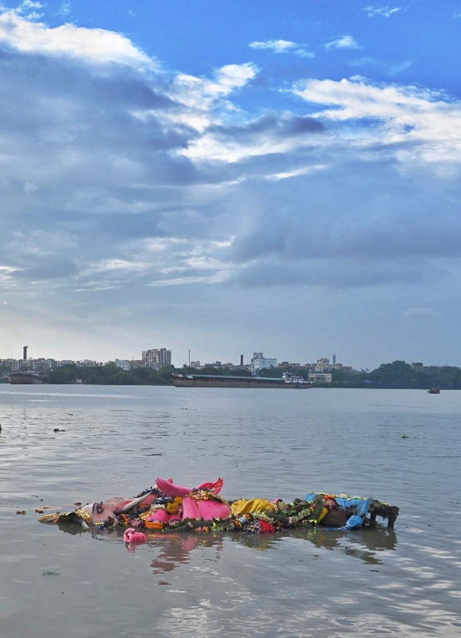 A Ganesh idol floats at Babughat after its immersion on Monday