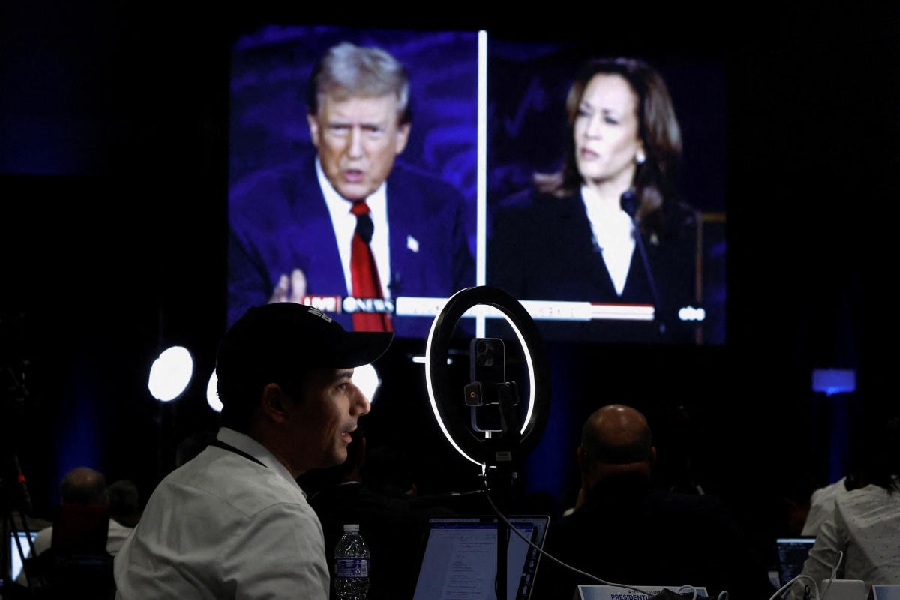 Members of the media use a screen to watch the presidential debate, as Republican presidential nominee, former U.S. President Donald Trump and Democratic presidential nominee, U.S. Vice President Kamala Harris attend a presidential debate hosted by ABC in Philadelphia, Pennsylvania, U.S.