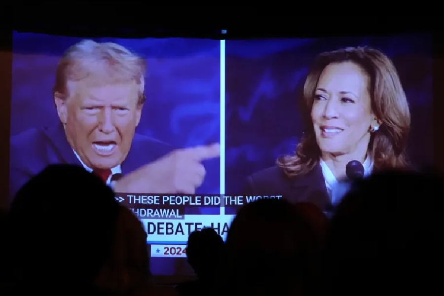 Viewers watch former President Donald Trump, left, and Democratic presidential nominee Vice President Kamala Harris during a presidential debate screening in Portland, Maine.