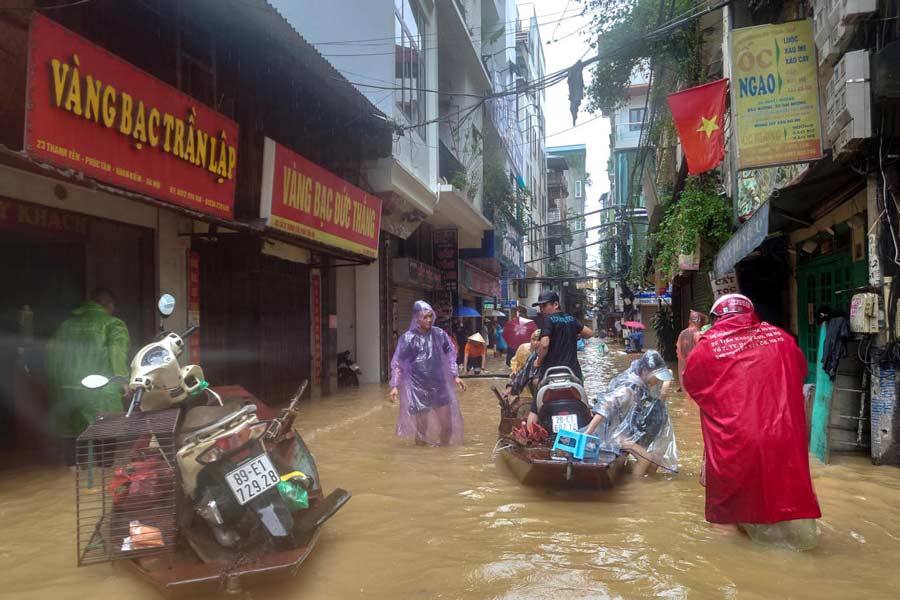 People wade through a flooded street following the impact of Typhoon Yagi, in Hanoi, Vietnam, September 11, 2024