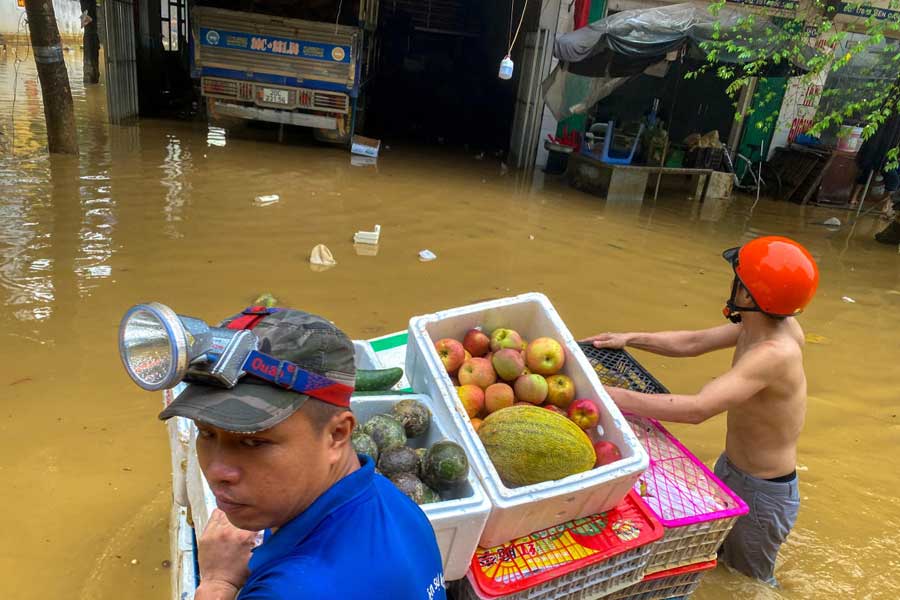 People wade through a flooded street following the impact of Typhoon Yagi, in Thai Nguyen City, Vietnam, September 11, 2024 