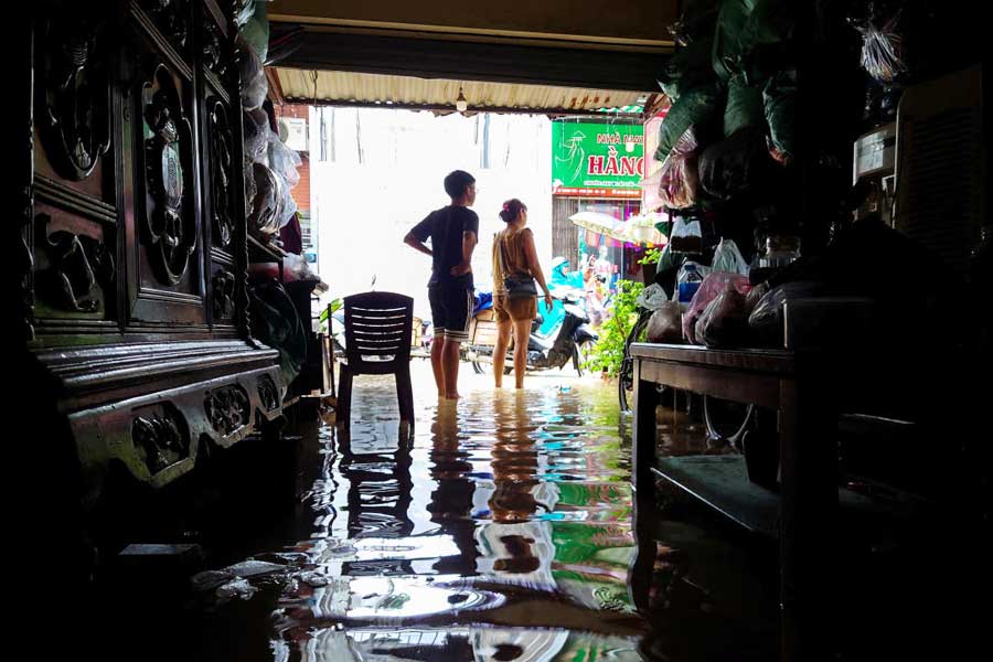 Shop owners stand inside their flooded shop following the impact of Typhoon Yagi, in Hanoi, Vietnam, September 11, 2024