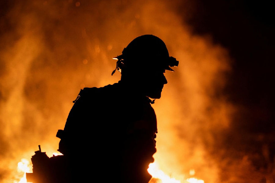 A Cal Fire firefighter tackles the Bridge Fire threatening mountain communities to the northeast of Los Angeles, in Wrightwood, California, U.S.