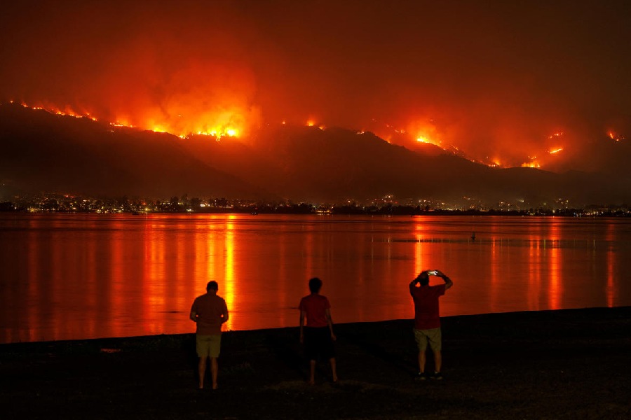 The Airport Fire burns along the hillside as residents watch from the shoreline in Lake Elsinore, California, U.S.