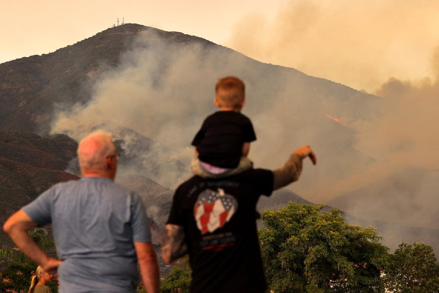 People look on, as the Airport Fire burns in the hills of Orange County, California, U.S.