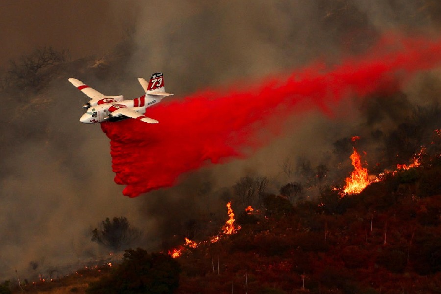An aerial tanker combats the Airport Fire, a wildfire burning in the hills of Orange County, California, U.S.
