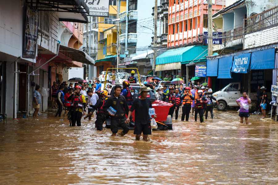 Rescue workers help stranded people from a flooded area at the border town of Mae Sai, following the impact of Typhoon Yagi, in the northern province of Chiang Rai, Thailand.