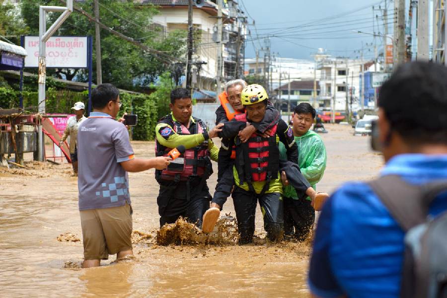 Rescue workers help stranded people from a flooded area at the border town of Mae Sai, following the impact of Typhoon Yagi, in the northern province of Chiang Rai, Thailand.