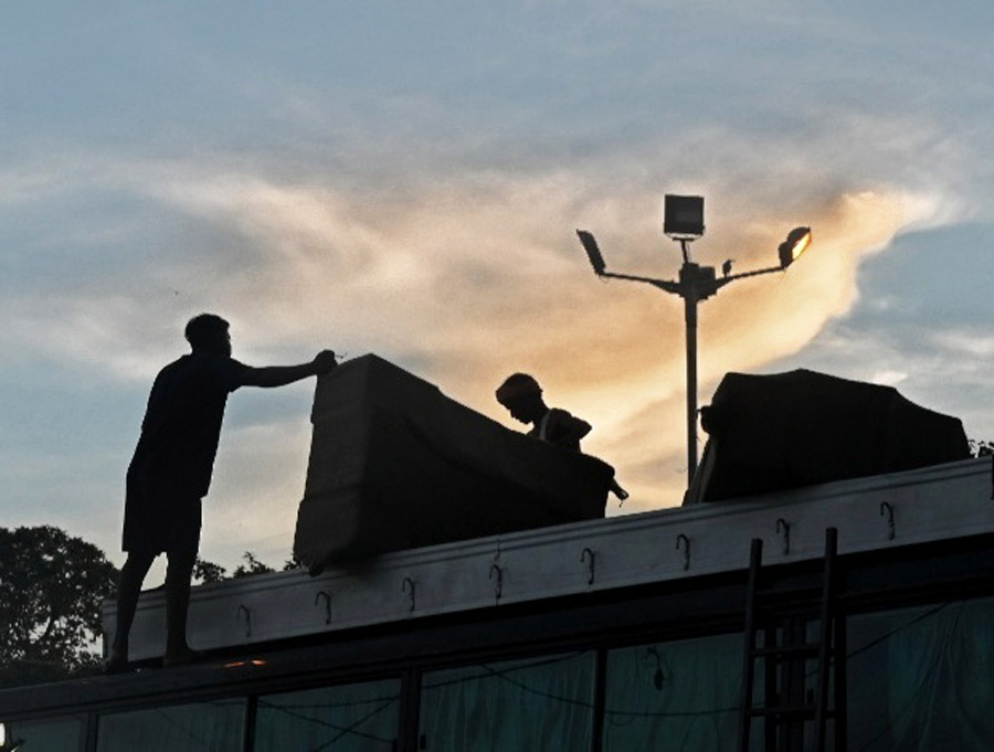 Labourers load luggage of passengers on the roof of a long-distance bus near Babughat on Thursday afternoon