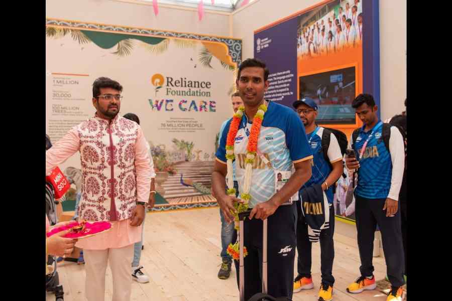 Devendra Kumar Chhajar waits to show table tennis veteran Sharath Kamal around at India House