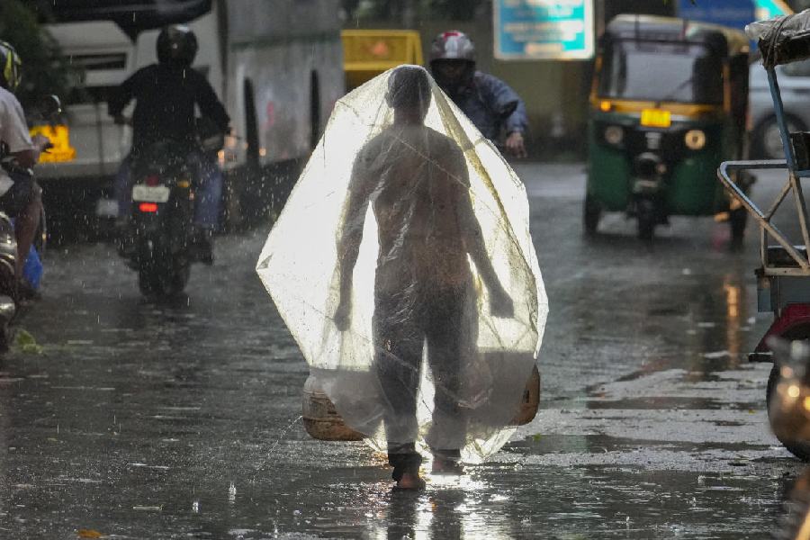 A man takes cover under a plastic sheet in New Delhi.
