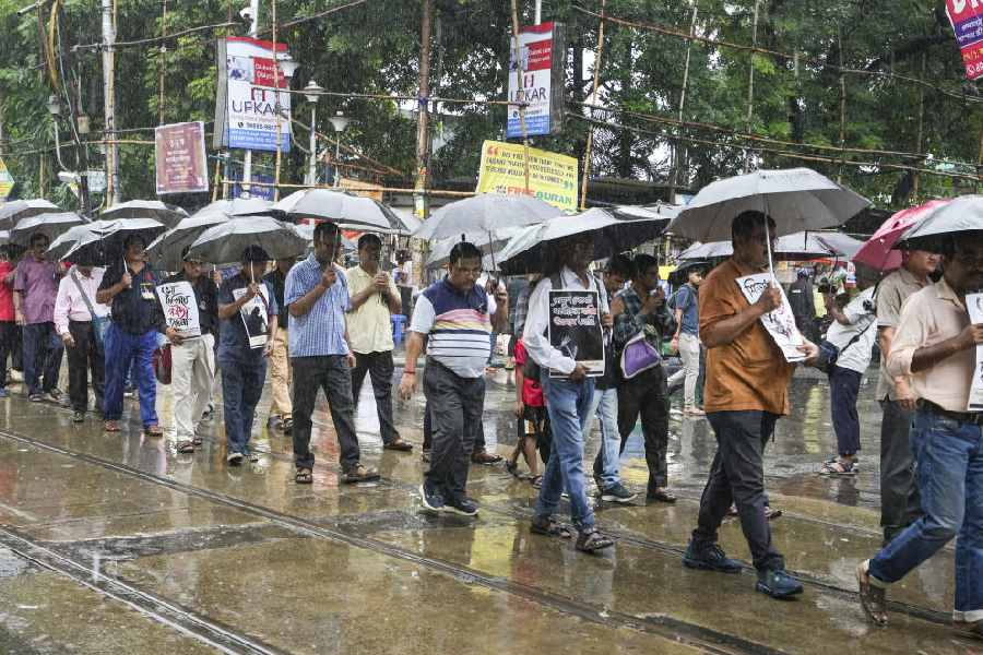 Joint forum of engineers, scientists and technologists participate in a rally during rain in protest against the alleged rape and murder of a medic at RG Kar Medical College and Hospital, in Kolkata, Saturday, Sept. 14, 2024. 