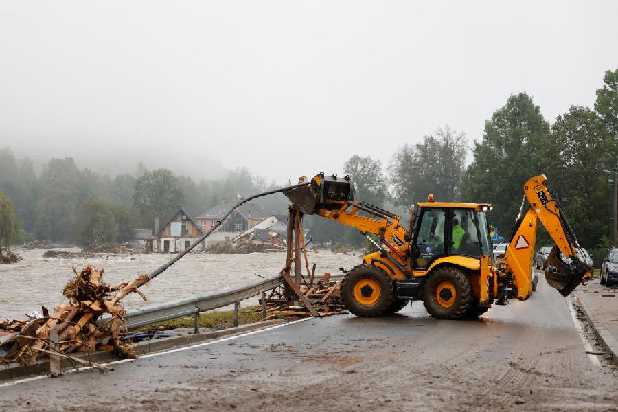 An excavator is used to clear debris next to a road, in the aftermath of flooding following heavy rainfalls, in Jesenik, Czech Republic, September 16, 2024.