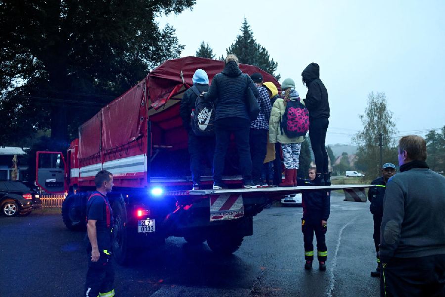 Evacuees stand on the back of a truck, following floods caused by heavy rainfalls in Visnova, Czech Republic.