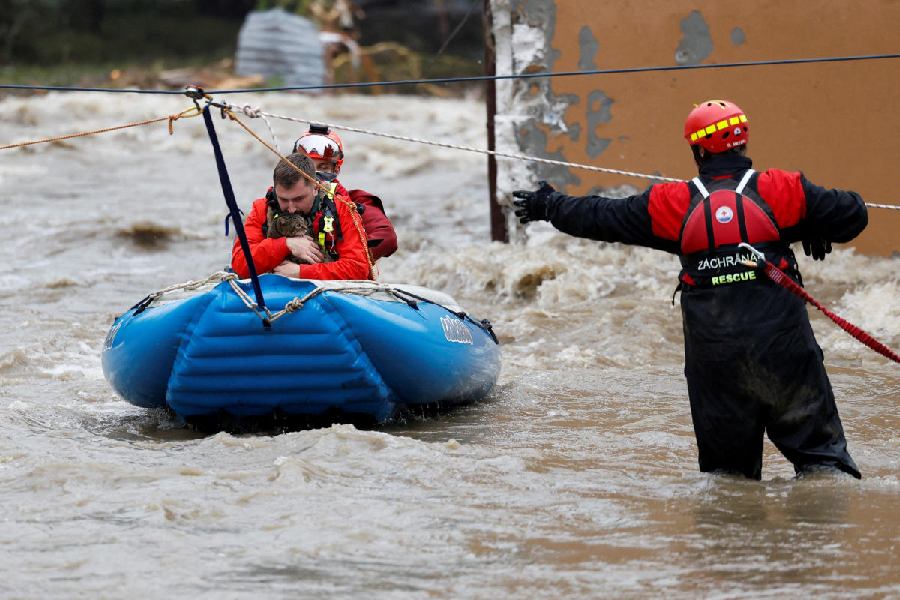 A man holds a cat as he is aided by rescuers on a flooded street, following heavy rainfall in Jesenik, Czech Republic.