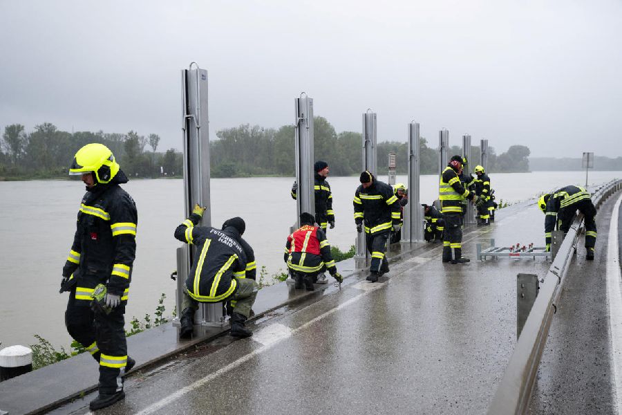 Firefighters assemble a water barrier next to river Danube to prevent flood water from spilling into streets in Mauthausen, Austria.