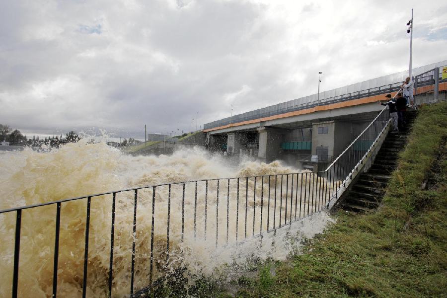 People view elevated water levels from the river Nysa Klodzka at Glebinow hydroelectric power plant in Nysa, Poland.